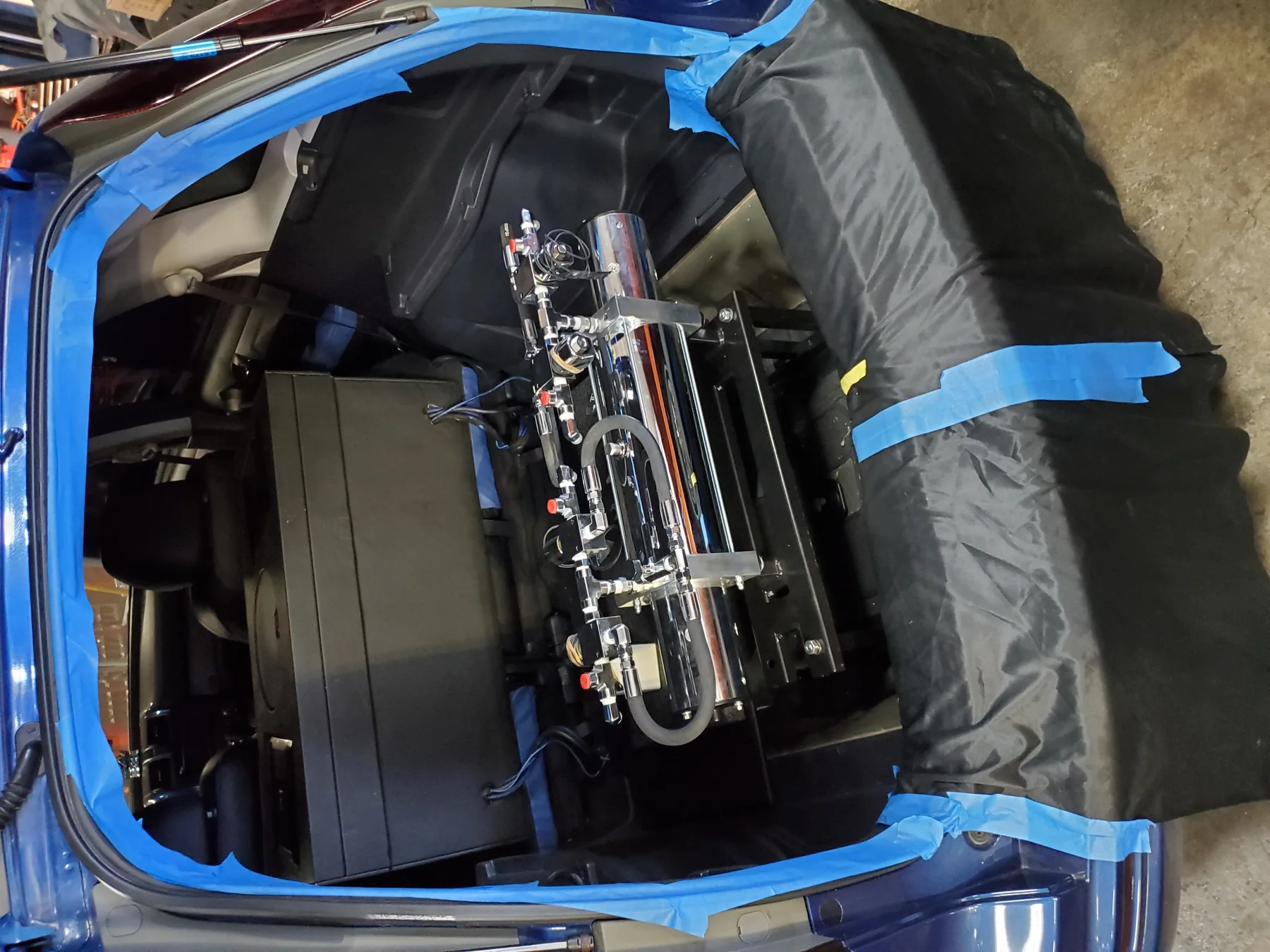 Custom hydraulic system being installed in a protected vehicle trunk
